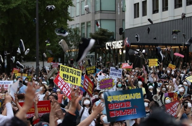 정부의 부동산 규제와 세금인상 등에 발반한 시민들이 25일 저녁 서울 중구 을지로 예금보험공사 앞에서 촛불집회를 열었다. 시위 참가자들이 신발을 던지는 퍼포먼스를 진행하고 있다. (자료 한경DB)