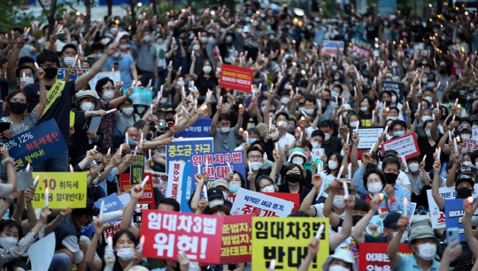 지난 25일 서울 중구 예금보험공사 앞에서 열린 '소급적용 남발하는 부동산 규제 정책 반대, 전국민 조세 저항운동 촛불집회' 참가자들이 촛불을 들고 있다. <연합뉴스>