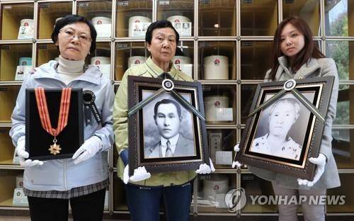 2019년 4월 22일 국립서울현충원에서 열린 계봉우 지사와 김야간 여사 유해 안장식에서 유족들이 영정과 건국훈장 독립장을 들고 있다. [연합뉴스 자료사진]