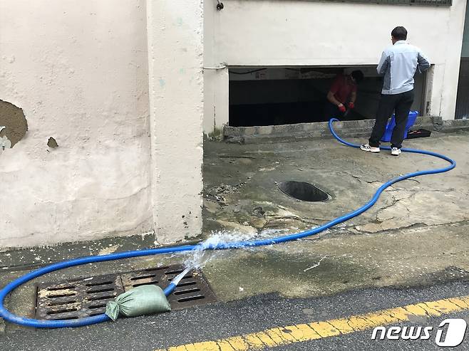 부산 동천 침수피해 지역 공장 직원들이 지하실에 차 있는 물을 빼내고 있다.2020.07.28/뉴스1 © 뉴스1 이유진 기자