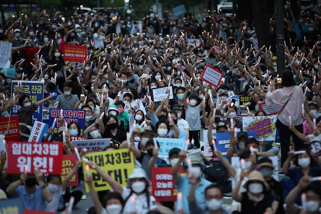 지난 25일 서울 중구 예금보험공사 앞에서 열린 ‘소급적용 남발하는 부동산 규제 정책 반대, 전국민 조세 저항운동 촛불집회’ 참가자들이 촛불을 들고 있다. (사진=연합뉴스)