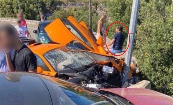 아드리안 수틸이 사고가 나 망가진 자신의 슈퍼카 옆에 앉아 있다. 그는 다친 데가 없다고 알려졌다. [트위터 캡처]