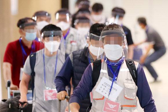 인천공항 통해 귀국한 파견 근로자들 - 31일 오전 인천국제공항을 통해 귀국한 이라크 건설 현장 파견 근로자들이 입국장에 들어서고 있다. 탑승 전 미리 실시한 코로나19 진단검사에서 양성 판정을 받은 근로자들은 의료기관 또는 생활 치료센터에 이송돼 치료를 받게 되며 음성 판정을 받은 경우 임시 생활시설에서 2주 동안 격리된다. 2020.7.31 연합뉴스