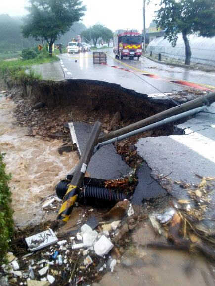 2일 오후 충북 충주시의 한 도로가 폭우로 유실된 모습. 연합뉴스