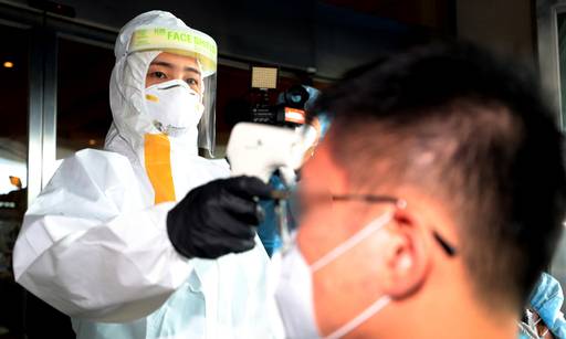 보건복지부 중앙사고수습본부 관계자가 5일 오후 인천의 한 임시생활시설에서 해외입국자 체온을 측정하는 것을 시연하고 있다. 인천=사진공동취재단