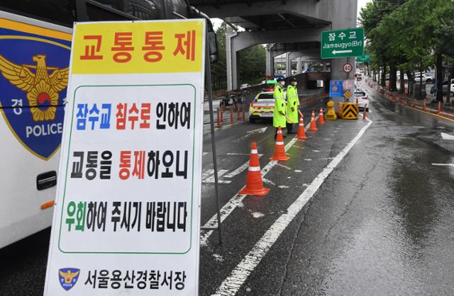 장맛비가 49일째 이어지고 있는 11일 오전 서울 잠수교 북단에서 경찰이 교통을 통제하고 있다. 배우한 기자
