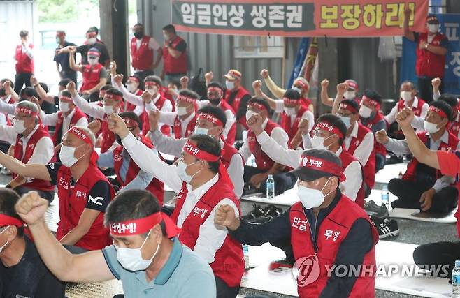 구호 외치는 남양여객 노조원들 (수원=연합뉴스) 홍기원 기자 = 11일 오전 경기도 수원시 권선구 남양여객 노조 사무실 앞에서 노조원들이 임금인상을 요구하며 구호를 외치고 있다.       남양여객 노조는 11일 첫차부터 운행을 중단하고 파업에 들어갔다. 2020.8.11 xanadu@yna.co.kr