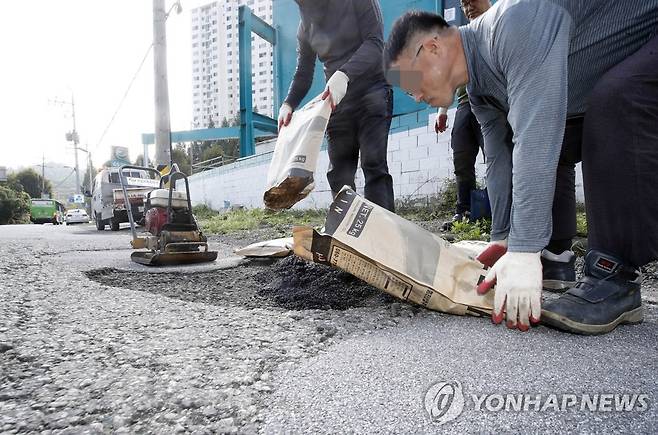 태풍에 생긴 도로 포트홀 복구작업 [연합뉴스 자료사진]
