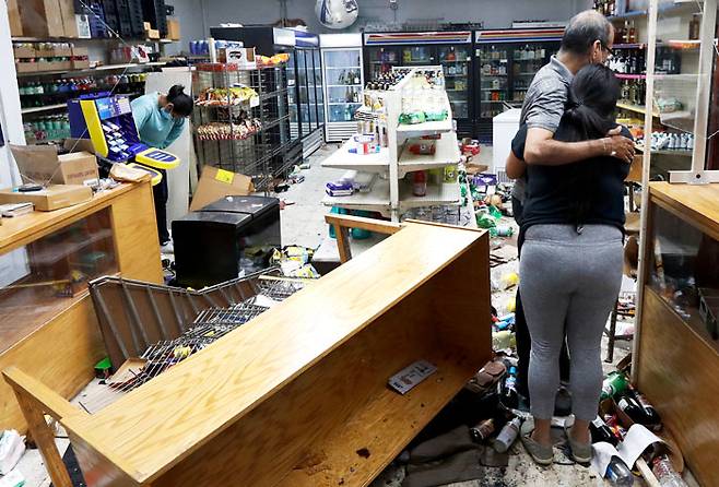 10일(현지 시각) 미국 일리노이주 시카고의 한 식료품점에서 점주 가족들이 약탈 피해를 입은 가게 안을 둘러보며 망연자실하고 있다. 현지 경찰은 이날 약탈 등의 혐의로 100여 명을 체포했다고 밝혔다. /AP 연합뉴스