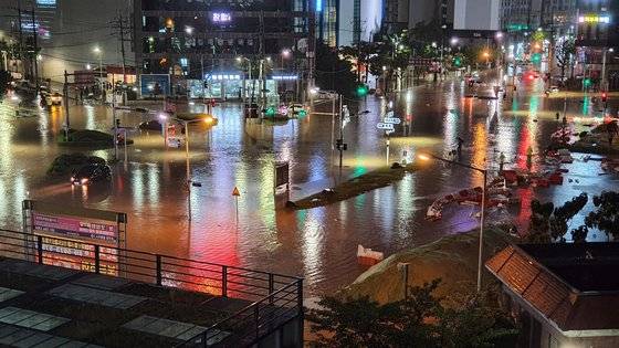 집중호우가 내린 지난달 24일 오후 부산 연제구 연산동 홈플러스 앞 사거리 도로가 침수돼 차량 운행이 통제되고 있다. 연합뉴스