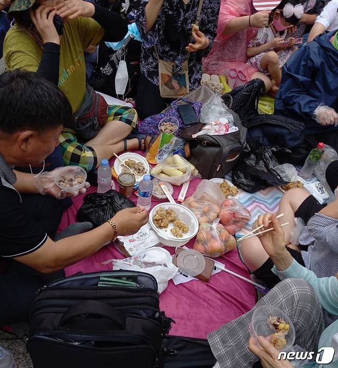 보수단체 '일파만파'가 서울 종로구 동화면세점 앞에서 개최한 집회에서 참가자들이 가지고 온 음식을 나눠먹고 있다. © 뉴스1 이밝음 기자