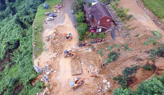 지난 3일 경기도 가평군 가평읍 산유리의 한 펜션에 토사가 덮쳐 소방당국이 중장비를 동원해 구조작업을 벌이고 있다.  소방당국에 따르면 펜션 사장 가족과 직원으로 추정되는 4명이 매몰됐으며 시신 3구가 수습됐다. [뉴스1]