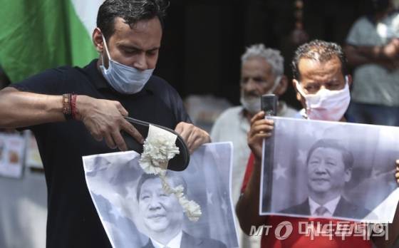 [잠무=AP/뉴시스]17일(현지시간) 인도 잠무에서 반중국 시위가 열려 시위대가 시진핑 중국 국가주석 사진을 신발로 때리고 있다. 일부 논평가들이 복수를 주장하는 가운데 인도 정부는 아직 공식 논평을 내지 않고 있다. 앞서 16일 인도-중국 국경지대에서 양국 군인이 충돌해 인도군 20명이 숨졌으며 중국의 피해 상황은 알려지지 않았다. 중국 당국은 이번 충돌이 인도가 중국군에 대해 전략적으로 오판한 결과라고 지적했다. 2020.06.17.