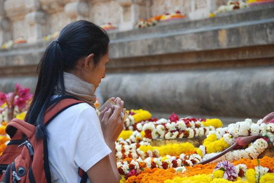부처님이 깨달음을 이룬 인도의 보드가야에 있는 대탑 앞에서 한 외국인 순례객이 기도를 하고 있다. 남방불교에서는 꽃으로 붓다에게 공양을 올리는 오랜 전통이 있다. 보드가야=백성호 기자