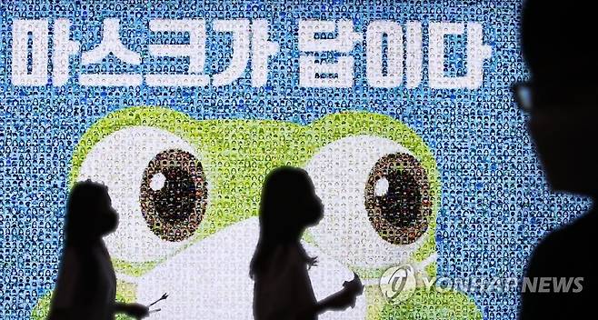 '마스크가 답이다' (수원=연합뉴스) 홍기원 기자 = 18일 오후 경기도 수원역에 설치된 마스크를 착용한 시민들의 사진을 모아 만든 '마스크가 답이다' 광고판 앞을 시민들이 지나고 있다. 2020.8.18 xanadu@yna.co.kr
