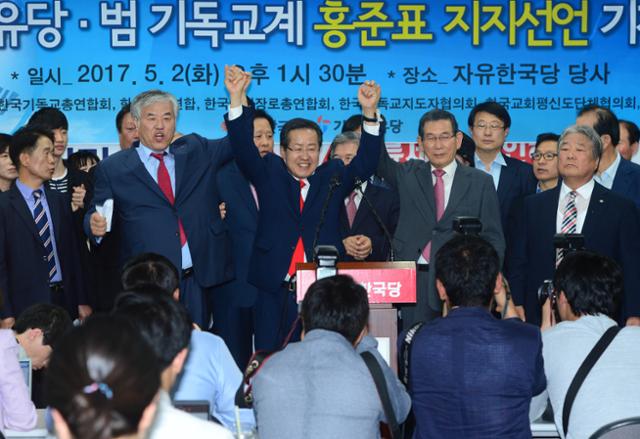 2017년 5월 2일 홍준표(가운데) 당시 자유한국당 대선후보가 서울 여의도 당사에서 열린 기독자유당ㆍ범기독교계 홍준표 지지 선언 기자회견에 참석, 전광훈(왼쪽 두 번째)목사와 손을 들고 인사를 하고 있다. 한국일보 자료사진