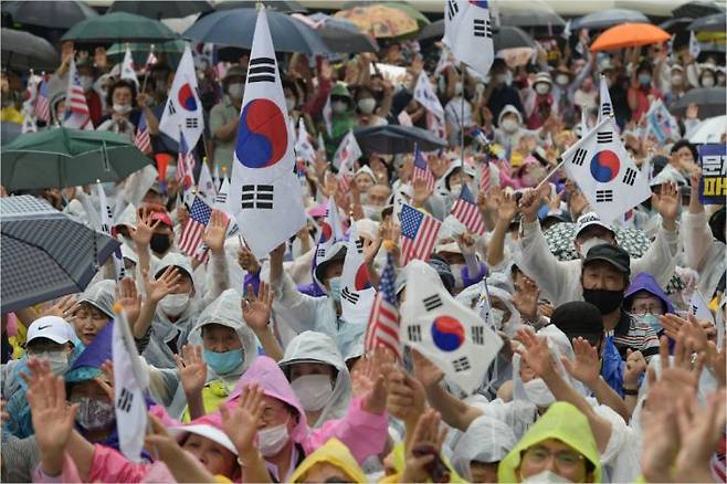 15일 오후 서울 종로구 동화면세점 앞에서 열린 보수단체의 광복절 집회에서 참서자들이 태극기와 성조기를 흔들고 있다. 이한형기자