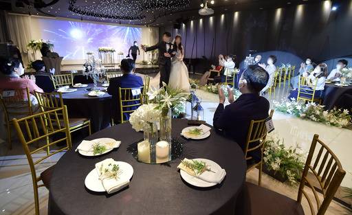 수도권을 중심으로 코로나19 확진자가 급증함에 따라 정부가 '사회적 거리두기' 2단계 방역강화 조치를 전국으로 확대한 가운데 23일 서울 시내 한 예식장에서 하객들이 번호표가 붙은 의자에 띄엄띄엄 앉아 있다. 이번 방역당국의 조치로 결혼식과 같은 실내 모임 및 행사는 참석 인원이 50명 미만으로 제한된다. 하상윤 기자