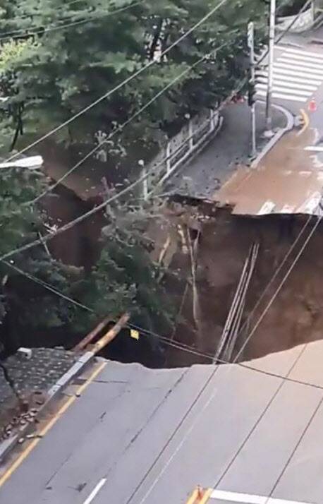 26일 오후 경기도 구리시 수택동 한양아파트 인근 도로에서 땅 꺼짐 현상(싱크홀)이 발생하면서 주변 나무들이 싱크홀과 함께 무너지고 있다. (사진=연합뉴스)