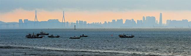 일출 직전에 인천 영종도에서 잠진도를 딛고 무의도로 건너가는 연도교에서 바라본 인천의 모습. 왼쪽에 인천대교의 주탑이, 오른쪽으로는 인천 연수구 일대의 모습이다. 바다 건너로 바라보는 인천은, 새로운 시선의 경험이다.