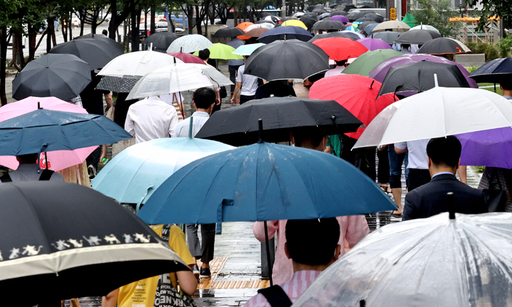 지난 27일 오전 서울 영등포구 여의도역 인근에서 시민들이 우산을 쓴 채 걸어가고 있다. 연합뉴스