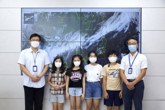 학생기자단이 오 예보분석관(왼쪽)과 박 주무관에게 설명을 들은 후 위성 영상을 배경으로 사진을 찍었다.