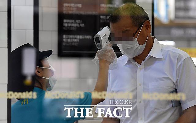 매장에 들어서며 체온을 측정하는 이용객들