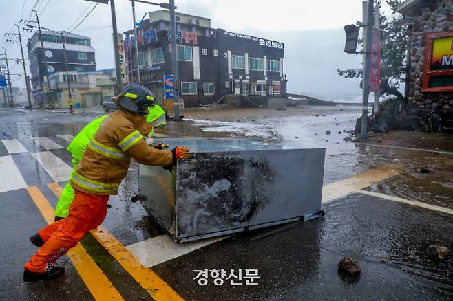 제10호 태풍 ‘하이선’이 지나간 7일 경찰과 소방대원이 경북 포항 구룡포 도로에 밀려온 냉장고를 도로 밖으로 밀어내고 있다.  2020.09.07 / 포항 | 이석우 기자