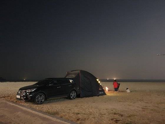 해수욕장에서 취사와 야영을 하는 건 과태료 10만원에 해당하는 불법 행위다. 강원도 고성의 한 해수욕장에서 모닥불을 피운 채 쉬고 있는 차박족의 모습. [중앙포토]