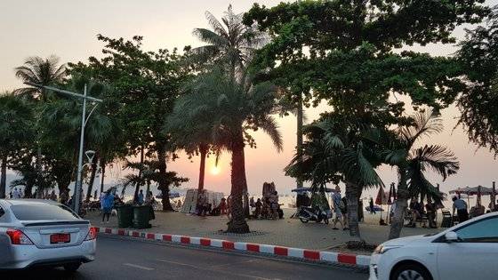 파타야 해변 야자나무 사이로 떨어지는 일몰과 해변가 풍경.