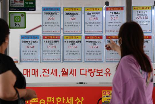 이달 서울 아파트 매매 건수가 역대 최저치를 기록할 것으로 예측되는 가운데 20일 서울 마포구 아현동 한 부동산 중개업소 앞에서 한 시민이 아파트 시세 게시물을 살펴보고 있다.  김동훈 기자