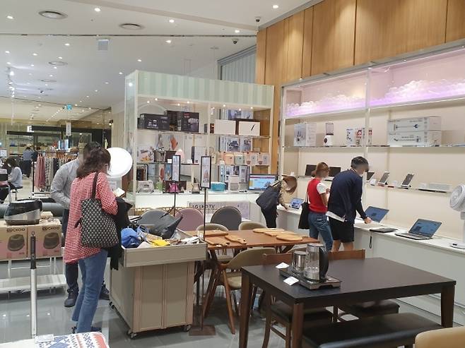 24일 리퍼브 매장 '리씽크' 롯데몰 광명점 내부 모습. 손님들이 노트북, 가방 등 리퍼브 상품을 살펴보고 있다. /사진=정혜윤 기자