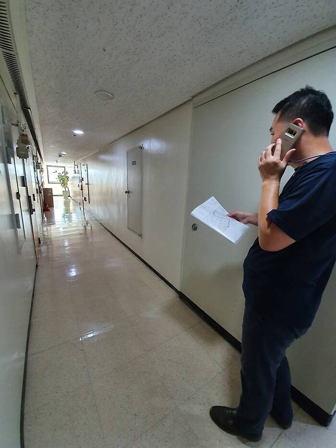 강남구청 재난안전과 박경욱 주무관이 지난 24일 자가격리 대상자의 문 앞에서 전화로 준수사항을 전달하고 있다.