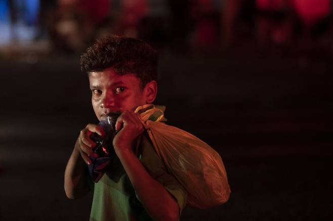 자신을 호르헤라고 밝힌 한 어린이가 1일(현지시간) 과테말라 모랄레스에서 온두라스 출신의 다른 이민자들과 함께 휴식을 취하며 물을 마시고 있다. (AP Photo/Moises Castillo)