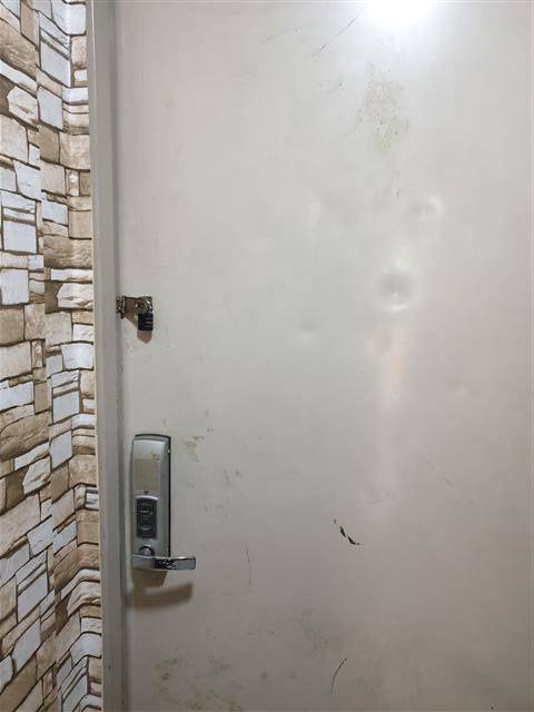 가족에게만 지워진 돌봄의 굴레 - 발달장애 아들이 혼자 문을 열고 나가지 못하도록 자택 현관 안쪽에 자물쇠를 채워 놓은 모습. 아들의 주먹질과 발길질로 현관문은 울퉁불퉁하게 변형됐다.오씨 제공