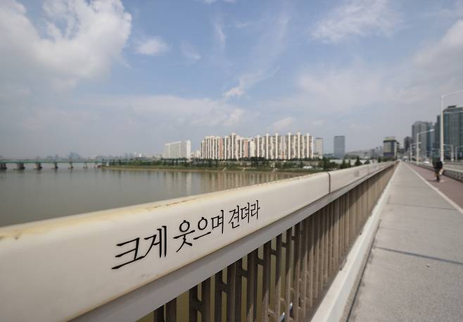 세계 자살예방의 날인 10일 서울 한강 한강대교 보도 난간에 '크게 웃으며 견뎌라'는 문구가 새겨져 있다. [연합]