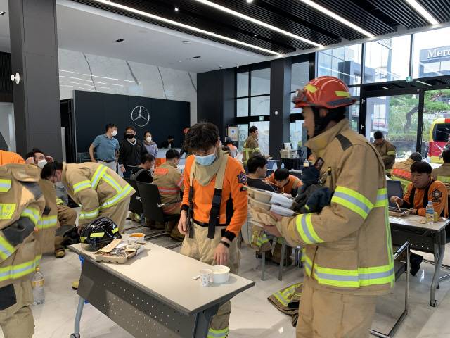 9일 오전 울산 남구 달동 벤츠 딜러사 스타자동차 영업점에서 삼환아르누보 화재를 진압하던 소방관들이 식사를 하고 있다./사진제공=스타자동차