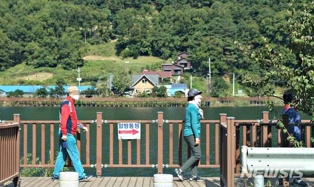 [증평=뉴시스]강신욱 기자 = 주말인 10일 충북 증평군 증평읍 율리 삼기저수지 등잔길 데크로드에 가을 정취를 느끼려는 사람들의 발길이 이어지고 있다. 신종 코로나바이러스 감염증(코로나19) 사회적 거리두기에 따라 방문객들이 일정 거리를 두고 한 방향으로 걷고 있다. 2020.10.10. ksw64@newsis.com