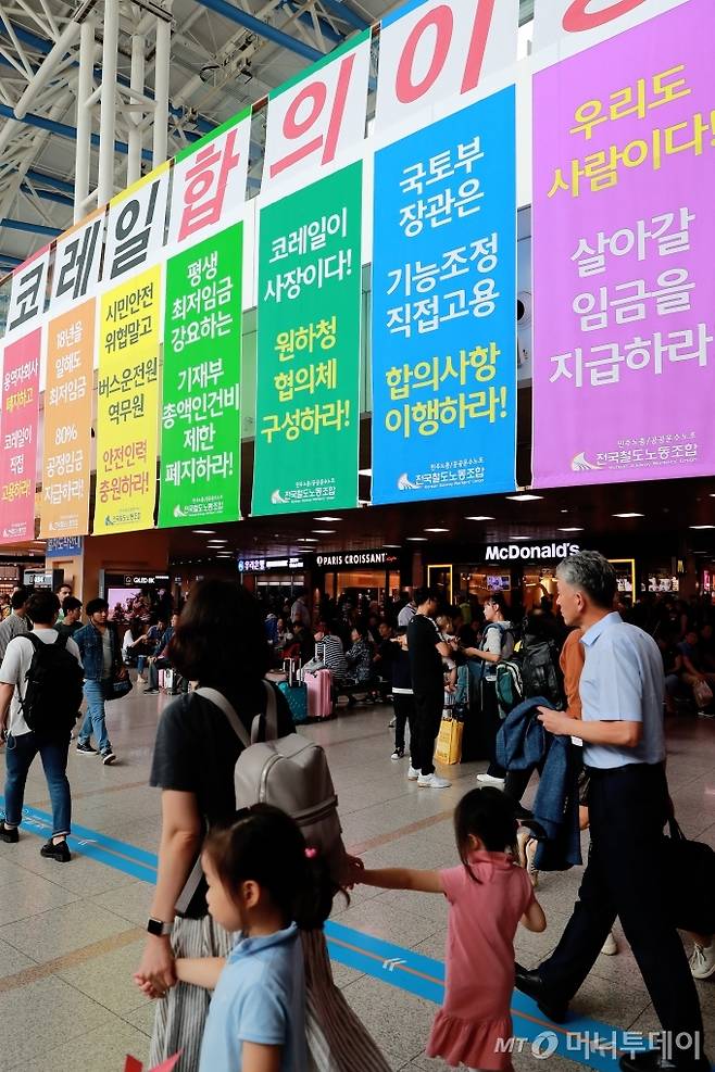 KTX·SRT 고속철도 승무원들이 직접고용·처우개선 등을 요구하며 파업에 들어간 가운데 추석 연휴의 마지막날인 15일 오후 서울역 대합실에 걸린 대형 현수막 앞으로 귀경객들이 지나가고 있다. 이번 고속철도 승무원들의 파업은 16일까지 예정돼있으며, 이에 코레일측은 대체인력을 투입해 고객안내 등 일부를 제외한 열차운행에는 차질이 없을 것이라고 밝혔다. / 사진=이동훈 기자 photoguy@
