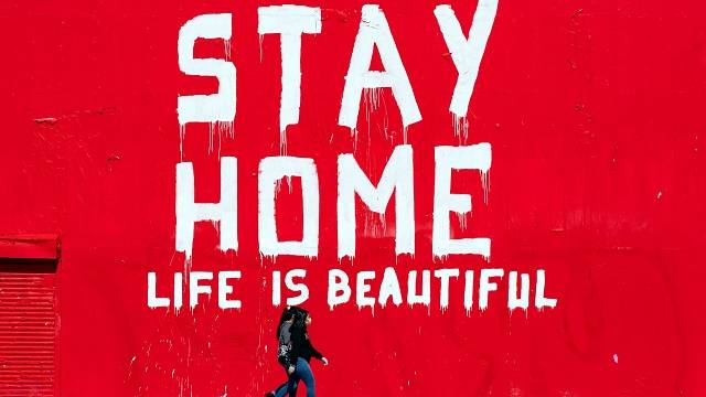 미국 L.A에 코로나19가 확산하고 있는 가운데 마스크를 쓴 두 사람이 벽화 아래를 지나가고 있습니다. [사진출처 : Étienne Laurent / EPA]