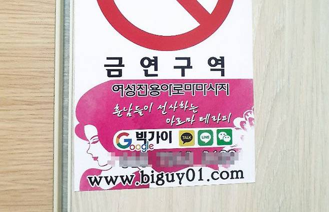 서울 중구 한 상가 건물 여성 화장실에 붙은 '여성전용마사지' 광고 스티커.