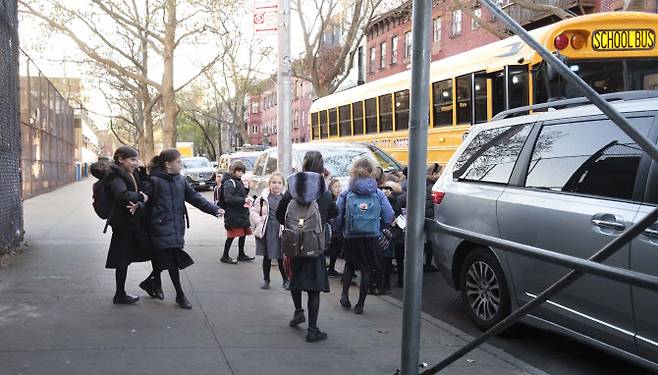 미국 뉴욕시 브루클린 지역의 한 공립학교에 재학하는 어린이들이 18일(현지시간) 수업을 마치고 통학 버스에 탑승하고 있다. (사진=EPA/연합뉴스 제공)