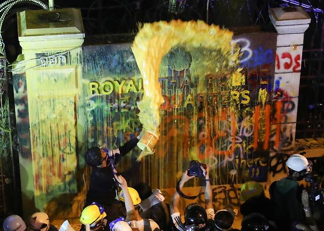 타이 민주화 요구 시위대가 18일 방콕 경찰청 건물에 페인트를 뿌리고 있다. 방콕/로이터 연합뉴스