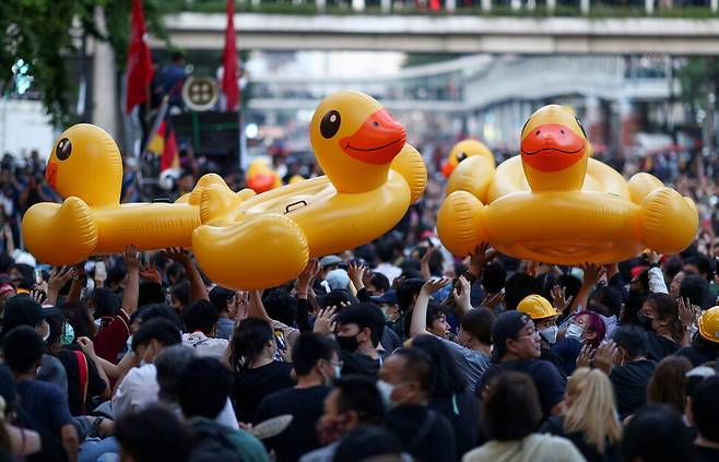 타이 민주화 요구 시위대가 18일 방콕 시위에 물놀이용 오리 모양 튜브를 들고 있다. 방콕/로이터 연합뉴스