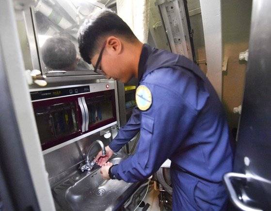 장보고함 승조원이 화장실 세면대에서 손을 씻고 있다. 잠수함 내 화장실에는 변기와 세면대가 같이 있다. 승조원은 40여명인데 비해 화장실은 단 2개뿐이라 5분 이내로 모든 용무를 마치는 것이 불문율이다.[사진 해군]