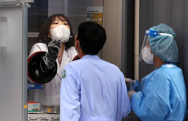 20일 오후 광주 동구 전남대학교병원 선별진료소에서 의료진이 코로나19 검사를 받고 있다. 연합뉴스