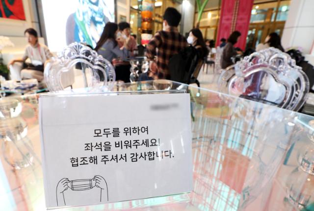 수도권과 강원 일부 지역의 사회적 거리두기가 1.5단계로 격상된 지난 19일 서울의 한 카페 테이블에 좌석을 비워달라는 안내문이 놓여 있다. 뉴시스