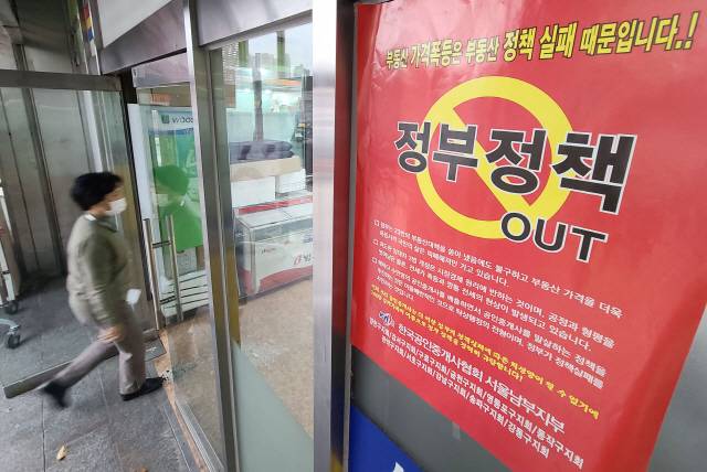 서울 시내 한 부동산 중개업소 외벽에 정부 집값 정책을 규탄하는 홍보물이 부착되어 있다./연합뉴스