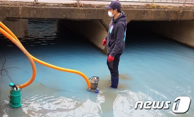22일 강원 춘천 효자교 아래 공지천의 물이 파란색으로 변해 시가 긴급 방제작업을 벌이고 있다.(춘천시 제공)© 뉴스1