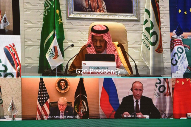 지난 21일 G20 화상 정상회의 주최국인 사우디아라비아 국왕이 개회사를 하는 가운데 도널드 트럼프(아래 왼쪽) 미 대통령이 고개를 숙인 채 뭔가를 적고 있다. /AFP연합뉴스